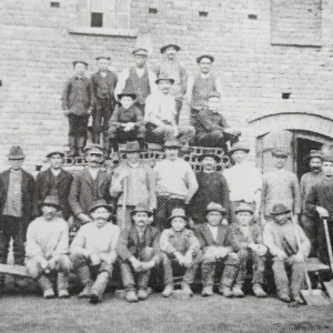 Robotnicy na tle cegielni. Stojący pierwszy od lewej w meloniku na głowie, to właściciel zakładu August Peter. Zdjęcie z 1910 roku (żródło: Krotoschiner Notizen Nr. 8/2014)